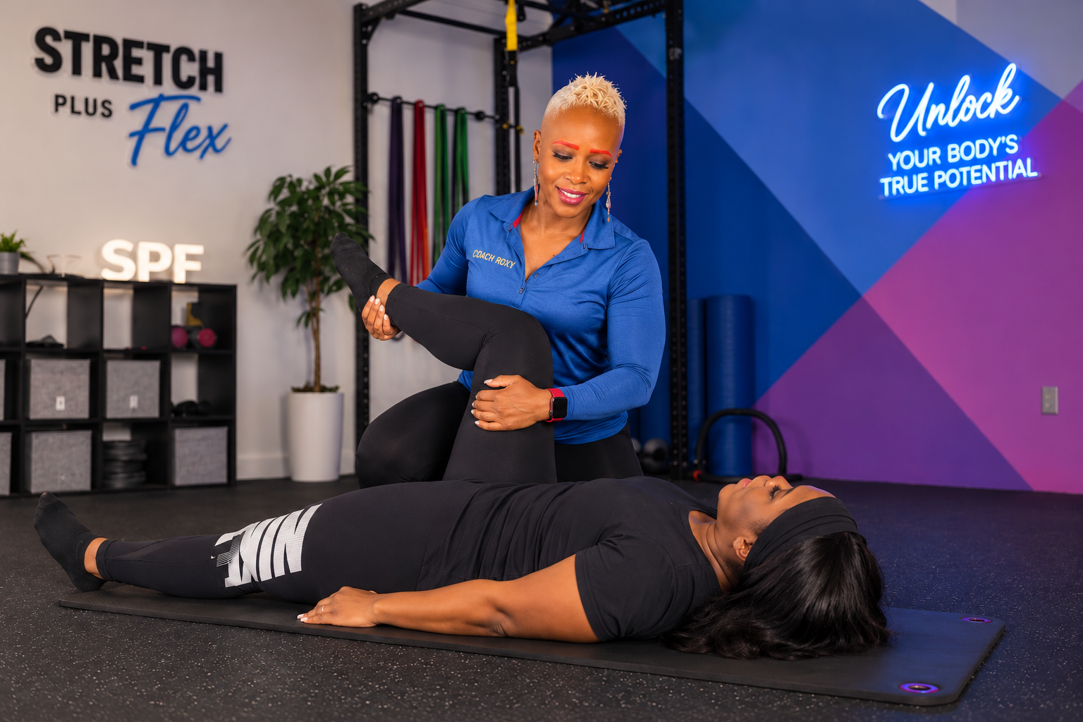 Coach Roxy leading an assisted leg stretch with a client on a mat at Stretch Plus Flex in Great Neck Plaza, NY